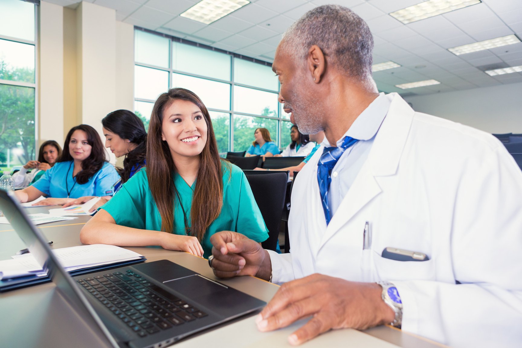 Healthcare student listening to senior doctor or professor during class